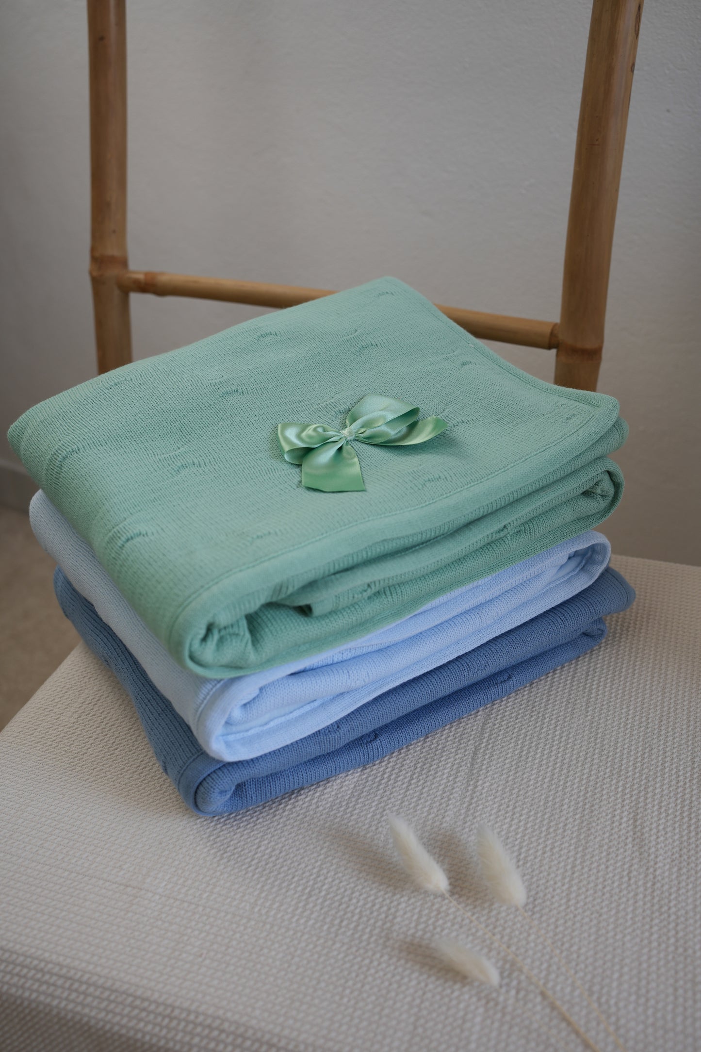 Embroidered knitted blanket with pompom