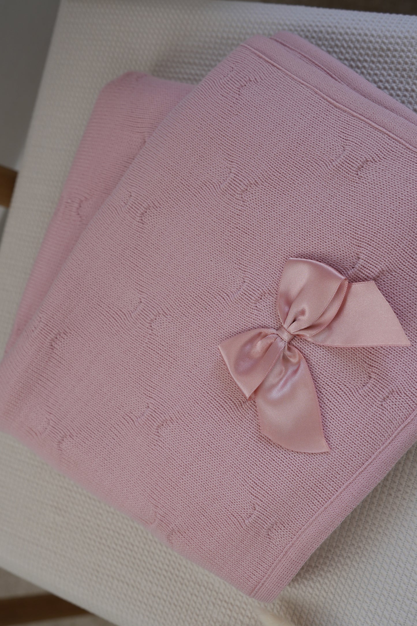 Embroidered knitted blanket with pompom